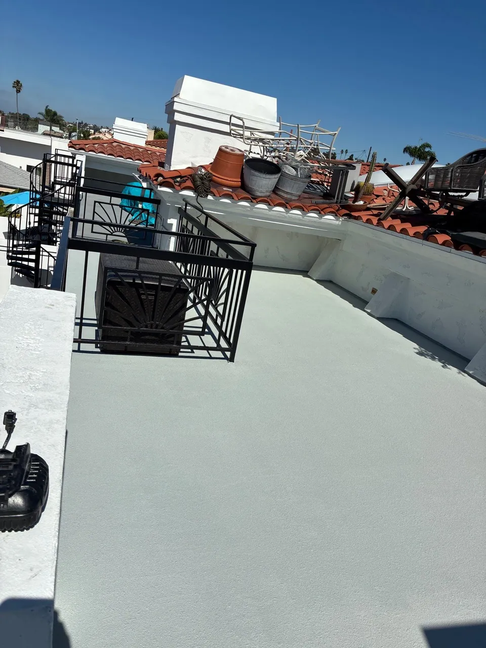 After waterproofing: completed light-colored AL-Flex rooftop deck surface with black metal railings in Hermosa Beach